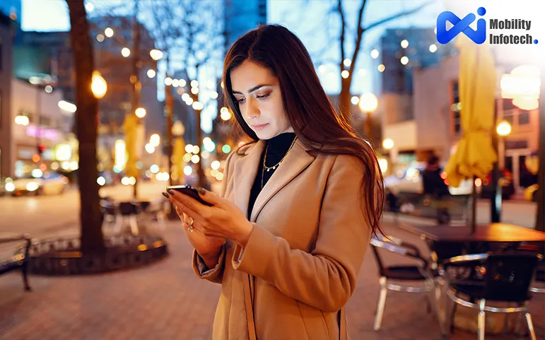 A girl stand alone in city road and checking smartphone